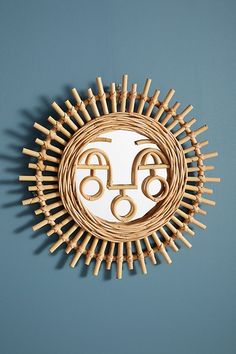 a wooden sun with two faces on it and some sticks sticking out of the side