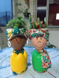 two ceramic pots with plants in them sitting on a table