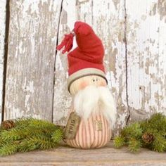 a gnome figurine sitting on top of a wooden shelf next to pine cones