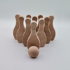 several wooden bowling pins and a ball on a white surface