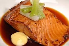 a piece of salmon on a plate with sauce