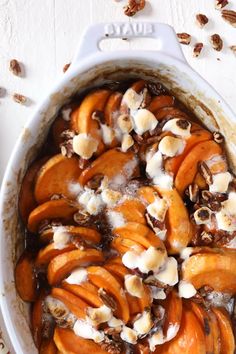 a casserole dish filled with sliced peaches, nuts and cinnamon on top