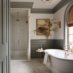 a bathroom with a bathtub, sink and shower in the corner next to a painting on the wall