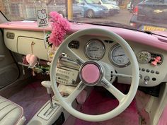 the interior of an old car with pink carpeting and steering wheel, dashboard gauges and dash board