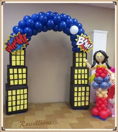 a balloon arch with a woman standing in front of it