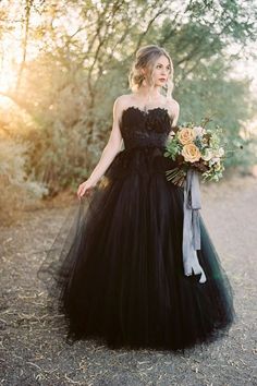 a woman in a black dress holding a bouquet