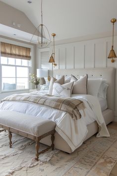 a large bed sitting in the middle of a bedroom next to a window with two lamps hanging above it