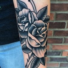 a black and white rose tattoo on the arm