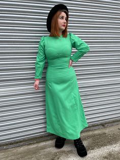 "▪️ 70s Kemit Maxi ▪️ ▪️ Stunning 1970s Empire Maxi Dress ▪️ Non stretch polyester fabric ▪️ Bright kermit green ▪️ Crew neckline with 3 decorative buttons to the waist ▪️ Long sleeves with huge cuffs ▪️ Fitted Waist ▪️ Maxi length flared skirt ▪️ Zips at the back ▪️ UK 10-12 Bust - 40\" Waist - 32\" Hips - 46\" Length - 54\" Follow us on Instagram for sneak peeks of new stock @ToxicVintageClothing.co!      Orders will be posted within 5 business days once payment is received. They will be sent Retro Fitted Maxi Dress For Fall, Retro Green Long Sleeve Maxi Dress, Green Long Sleeve Retro Maxi Dress, 1970s Style Fitted Maxi Dress, Fitted Retro Green Midi Dress, 70s Inspired Fitted Party Dress, 70s Inspired Long Sleeve Party Dresses, 1970s Fitted Green Maxi Dress, 1970s Style Fitted Green Maxi Dress