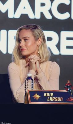 a woman sitting at a table in front of a microphone