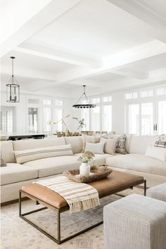 a living room filled with lots of white furniture