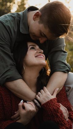 a man is hugging a woman's head while she holds her on his shoulders