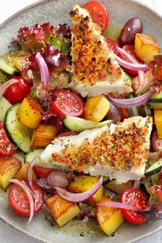 a white plate topped with fish and veggies