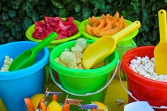 several buckets filled with food sitting on top of a table