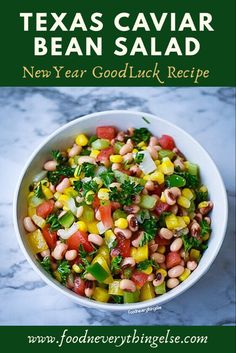 a white bowl filled with beans, corn and cilantro on top of a marble counter