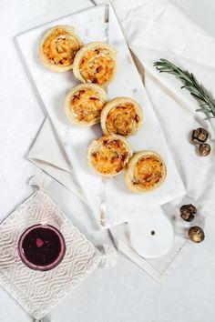 small appetizers on a white plate next to a glass of red wine