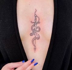 a woman's upper arm with a snake and dagger tattoo on her left shoulder