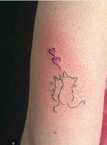 a cat with a heart shaped balloon tattoo on the leg is seen in this image