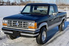 a black pickup truck is parked in the snow