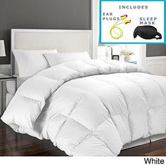 a white comforter in a bedroom next to a window with an advertisement on it