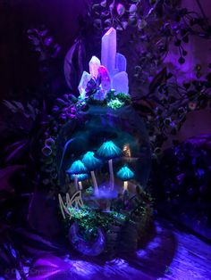 a glass ball with mushrooms and plants in the center is lit up by purple lighting