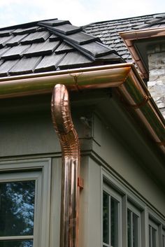 a copper gutter hose is attached to the side of a house's roof