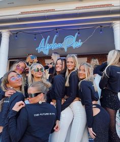 a group of women standing next to each other in front of a building