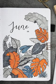 an open notebook with the word june written on it next to a pen and pencil