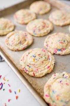 sprinkled cookies on a baking sheet ready to be baked in the oven with colorful sprinkles