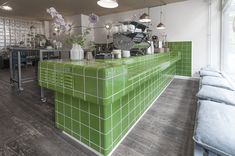 a green tiled bar in the middle of a room with white walls and wooden floors