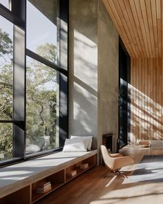 a living room filled with lots of windows next to a wooden floor covered in furniture