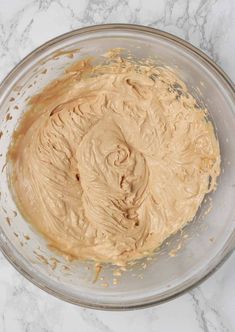 a bowl filled with peanut butter on top of a marble counter