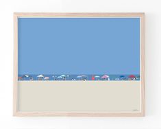 the beach is lined with umbrellas and chairs under a blue sky, framed in a wooden frame