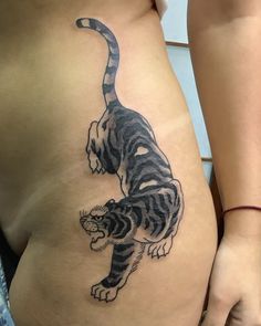 a woman's stomach with a tiger tattoo on her belly and the image of a cat