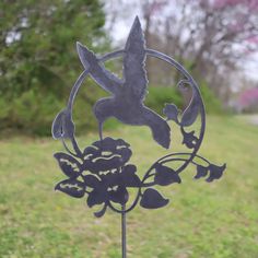 a metal stake with a bird and flowers on it