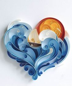 a paper cut out of the shape of a heart with waves and boats on it