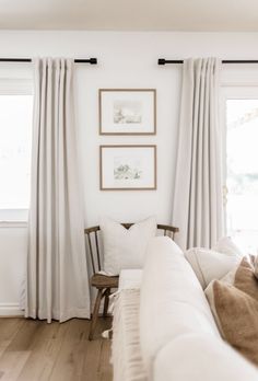 a living room with white walls and curtains