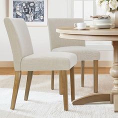 a dining room table with two chairs next to it