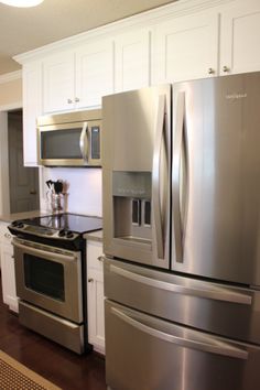 a kitchen with stainless steel appliances and white cabinets