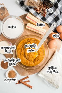 ingredients to make pumpkin pie laid out on a wooden cutting board, including eggs, butter, sugar and cinnamon