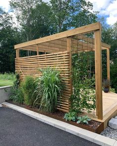 a wooden gazebo surrounded by plants and trees