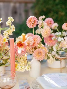 a table topped with vases filled with pink and white flowers