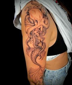 an octopus and mermaid tattoo on the back of a woman's left upper arm