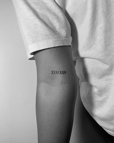 a person with a tattoo on their arm that says xivexvw in black and white