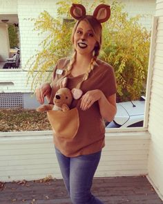 a woman is holding a teddy bear in her pocket while wearing a costume that looks like a mouse