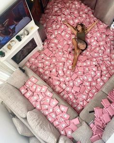 a woman laying on top of a bed covered in pink boxes