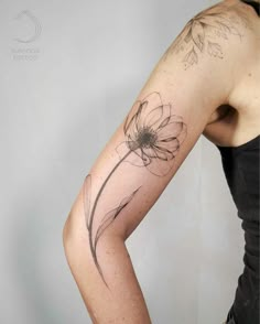 a woman with a flower tattoo on her arm