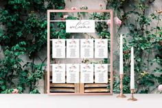 a table set up with seating cards and candles for an outdoor wedding ceremony in front of ivy covered wall