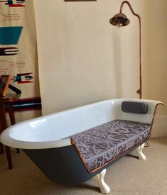 an old fashioned bathtub is in the corner of a room with a rug on the floor