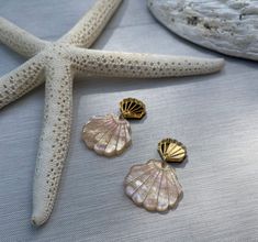 Bring our your inner mermaid with our pretty, summery seashell earrings. Inspired by the ocean and summer evenings, these gorgeous dangly earrings are laser cut and  engraved from a range of dreamy, specialist acrylics. Whether its irridesent mermaid vibes, pearlized acrylic with ripples that reflect the ocean or stunning mirrored acrylic, these will be sure to add a hint of summer to your wardrobe. Due to the nature of the marbled, pearlized acrylic, each piece is completely unique with the rip Mermaid Vibes, Mirrored Acrylic, Starburst Earrings, Seashell Earrings, Mermaid Inspired, Glitter Earrings, By The Ocean, Carved Designs, Beach Combing